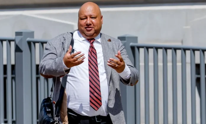 George Chidi in grey coat George Chidi in grey coat